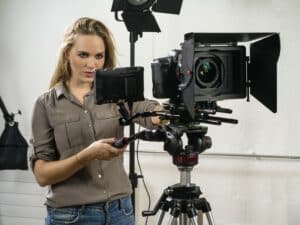Photo of a woman operating a dslr camera rig for a video shoot.